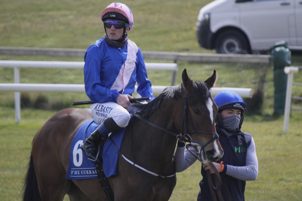 Lynne leading a horse towards the stalls at the Curragh