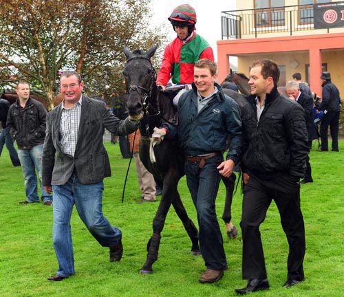 Mac's Conflict is led to the winner's enclosure - trainer Paddy Fegen is on the right