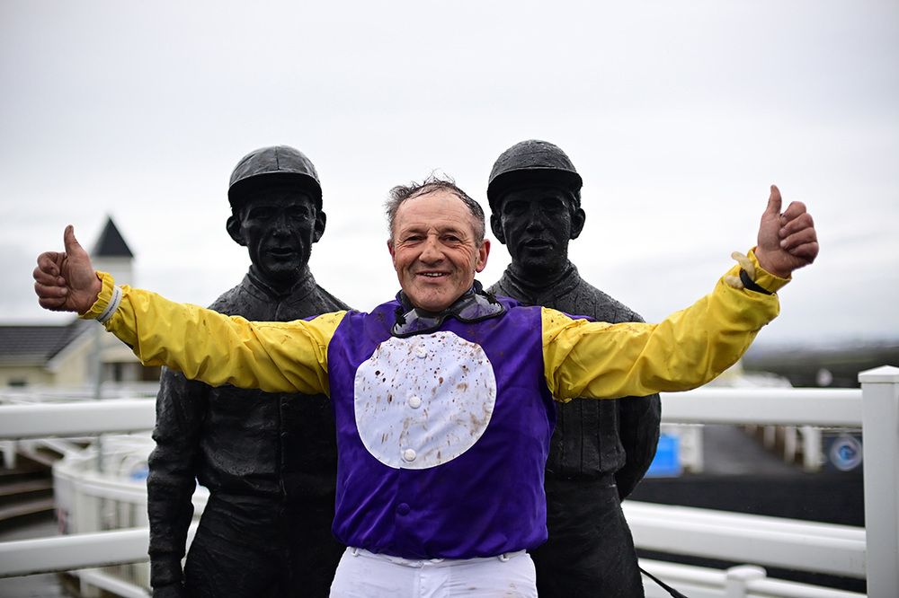 Liam Burke pictured with the statues of Tim and Martin Molony after winning on Teuchters Glory   